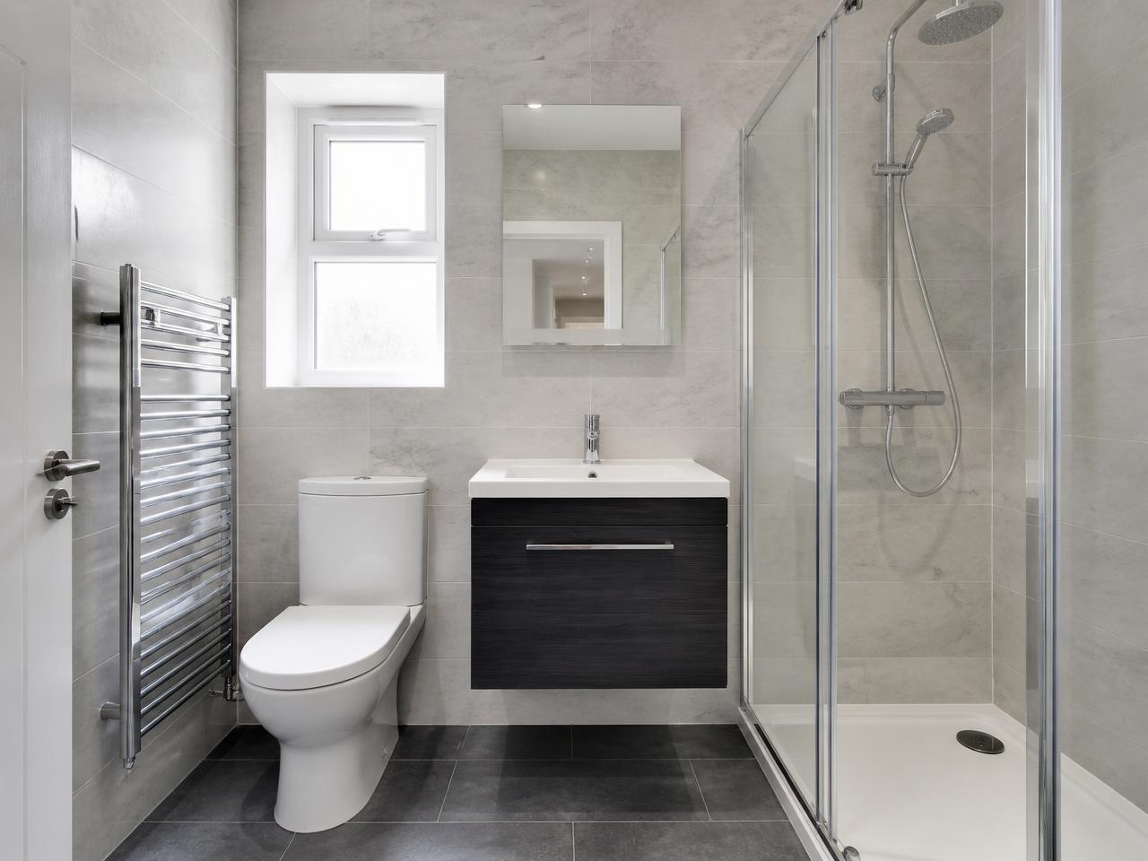 Renovated modern bathroom with walk-in shower and vanity unit